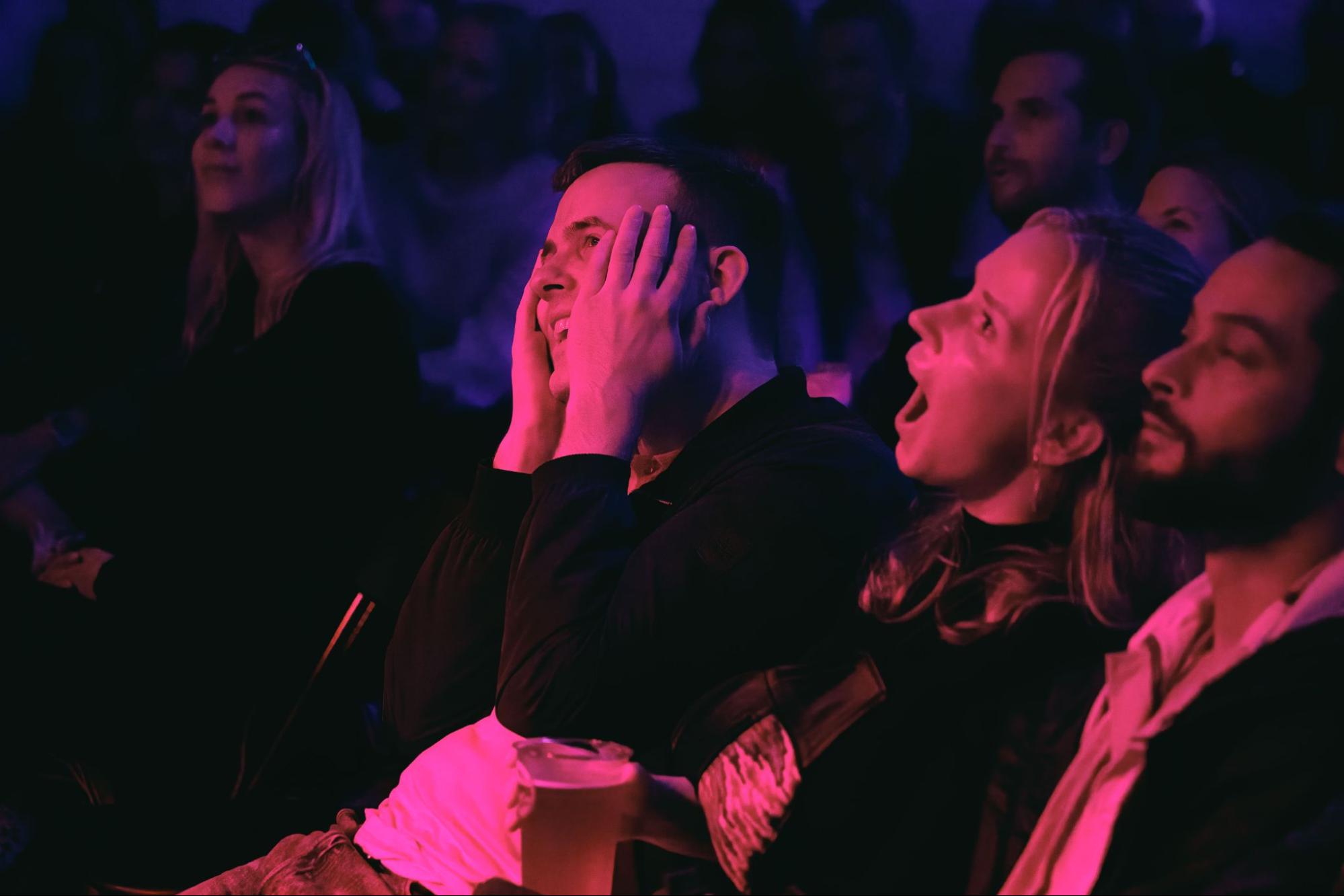 Publikummere som ler og blir overrasket av komikere på standupshow i Oslo